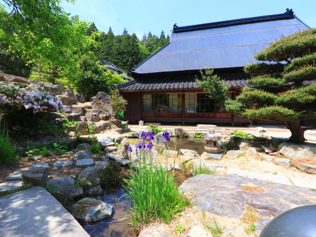 a garden with a pond in front of a house at 雲海の宿　月星亭 in Takeda