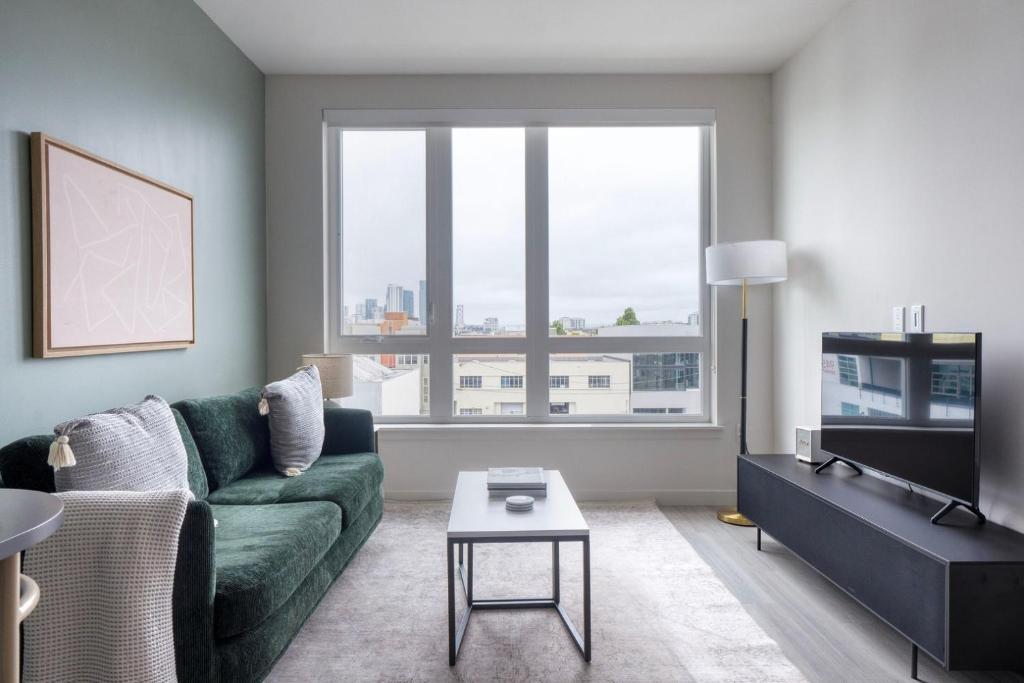 een woonkamer met een groene bank en een tafel bij SoMa 1br w bike storage parking nr Bart SFO-1424 in San Francisco