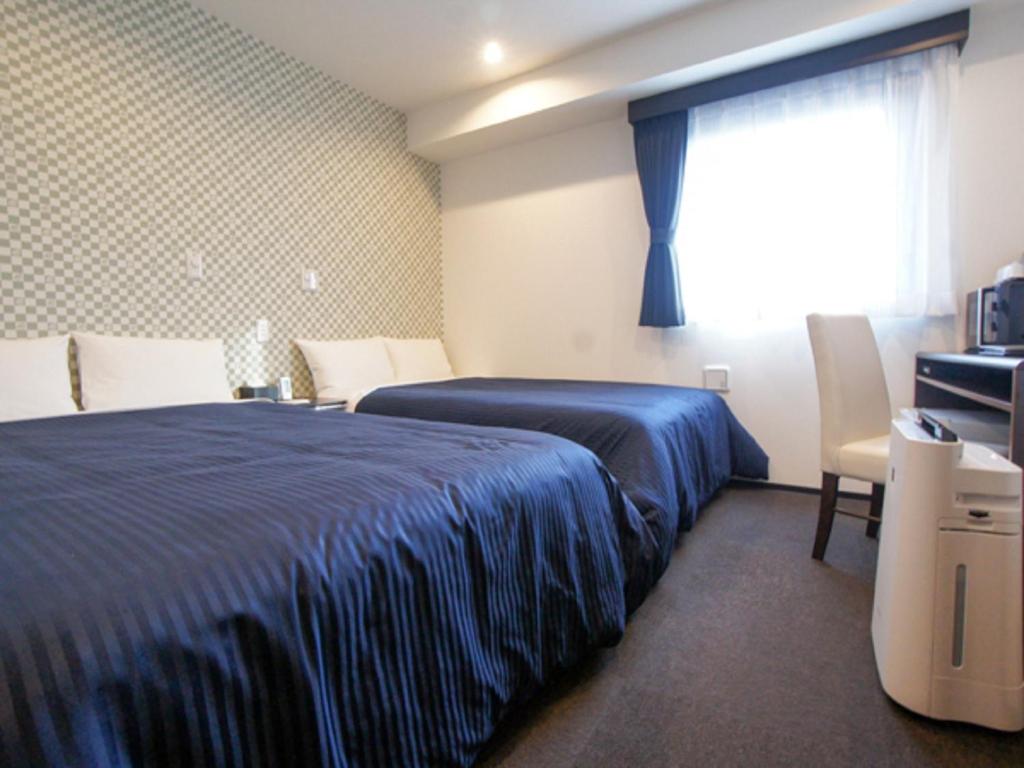 Postel nebo postele na pokoji v ubytování HOTEL LiVEMAX Minamihashimoto Ekimae