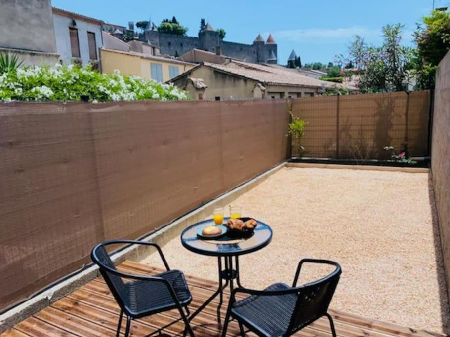 d'une terrasse avec 2 chaises et une table avec de la nourriture. dans l'établissement Studio du château climatisée, à Carcassonne