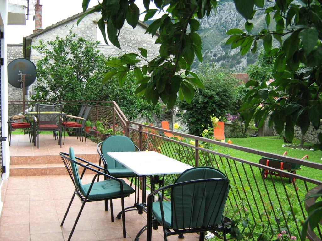 a patio with chairs and tables and a fence at Rooms & Apartments Vukasović in Kotor