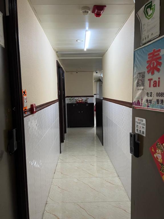 un couloir menant à une chambre dotée d'un hall avec une porte dans l'établissement 泰豪賓館, à Hong Kong