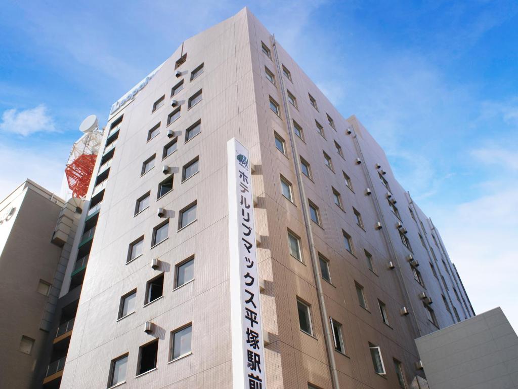 un edificio con un cartello sul lato di HOTEL LiVEMAX BUDGET Hiratsuka Ekimae a Hiratsuka