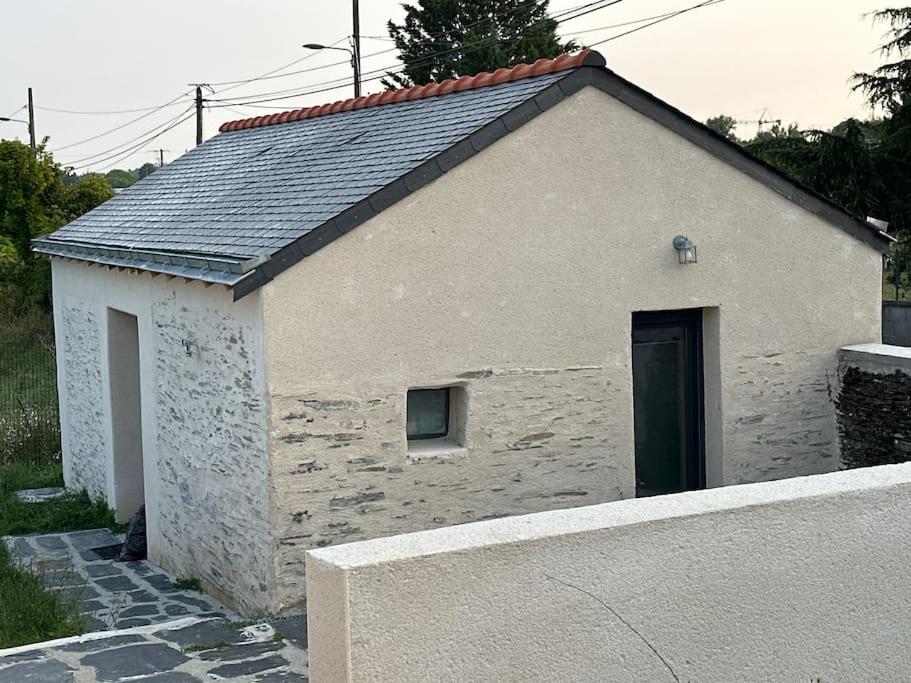 un petit bâtiment blanc avec une porte et une clôture dans l'établissement Petite maison 4/6 personnes, à Les Ponts-de-Cé