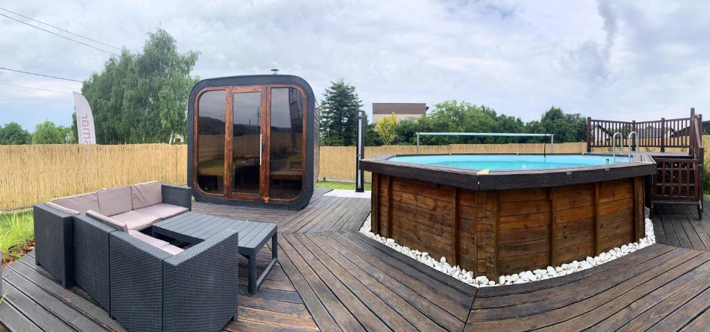 a hot tub sitting on a wooden deck with a bench and aitating at Apartament 106 in Andrychów