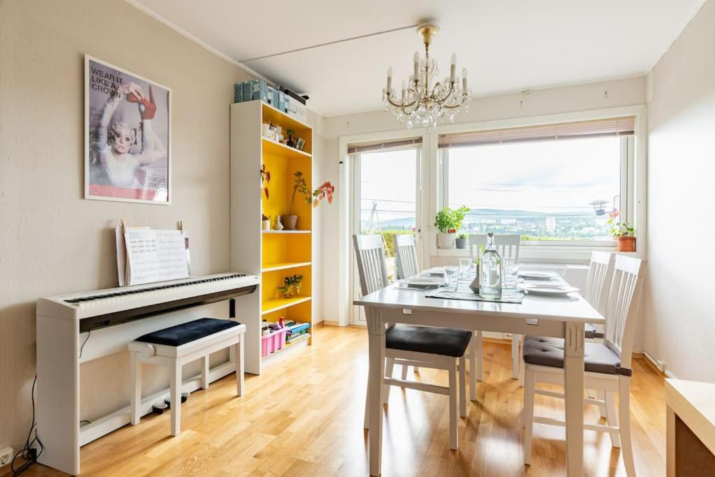 uma sala de jantar com uma mesa e um piano em Oslo: Quiet and cosy home with garden and free parking em Grorud