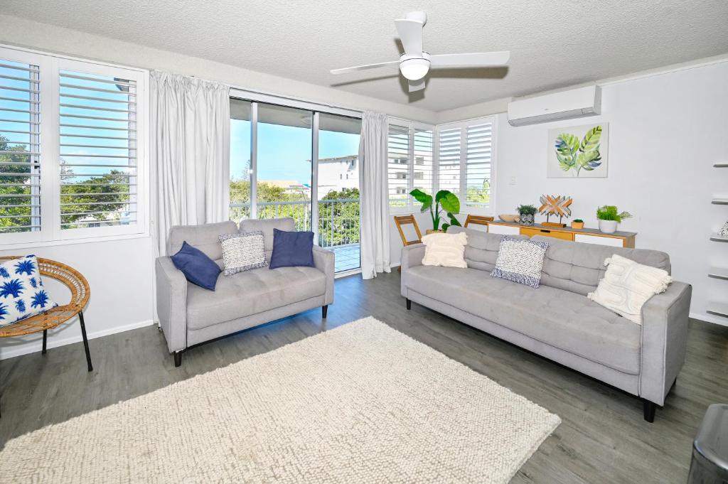 a living room with two couches and a ceiling fan at Spacious 3 Bedroom Delight - Shops & Beaches ZG1 in Caloundra