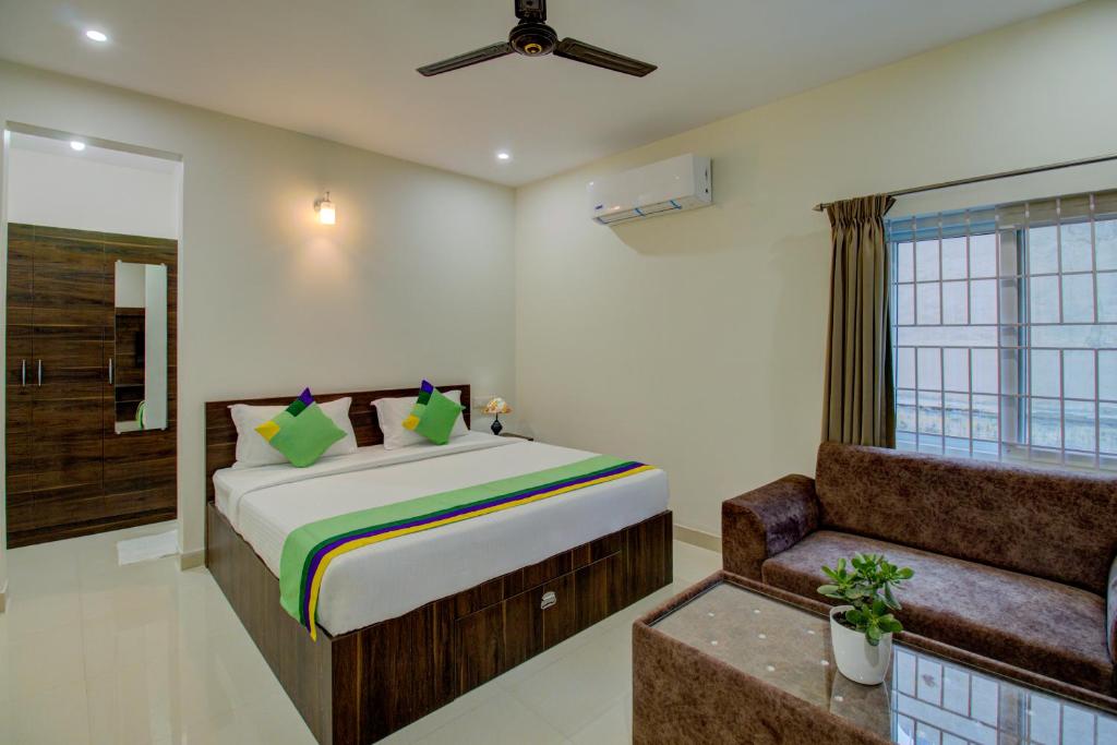 um quarto com uma cama, uma janela e um sofá em Treebo Trend Fortune Stay Inn em Bangalore