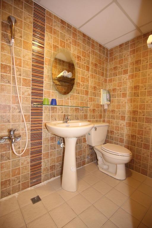 a bathroom with a toilet and a sink and a shower at Kenting Waterfront Hotel in Kenting