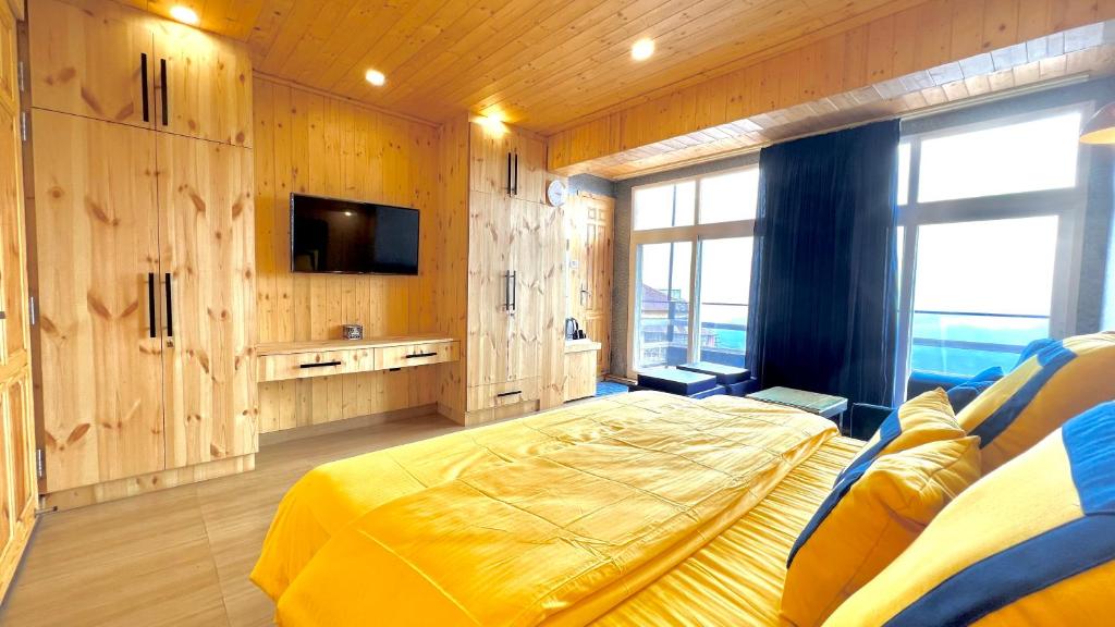 une chambre avec un lit et une télévision dans l'établissement Clarence Cottage, à Mussoorie