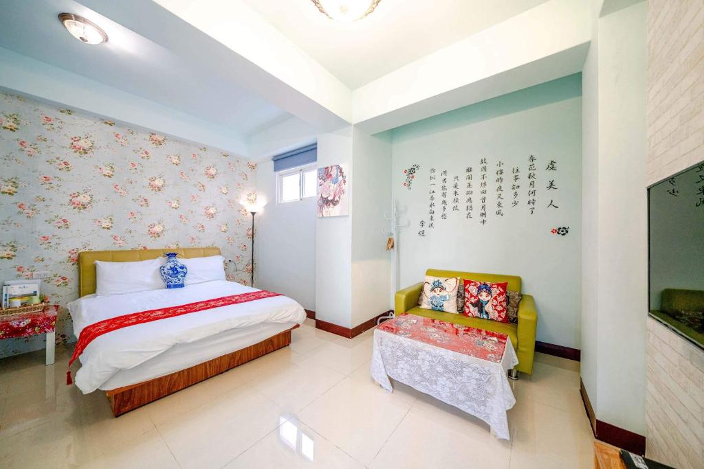 a bedroom with a bed and two chairs in it at Shanghai Time in Hualien City
