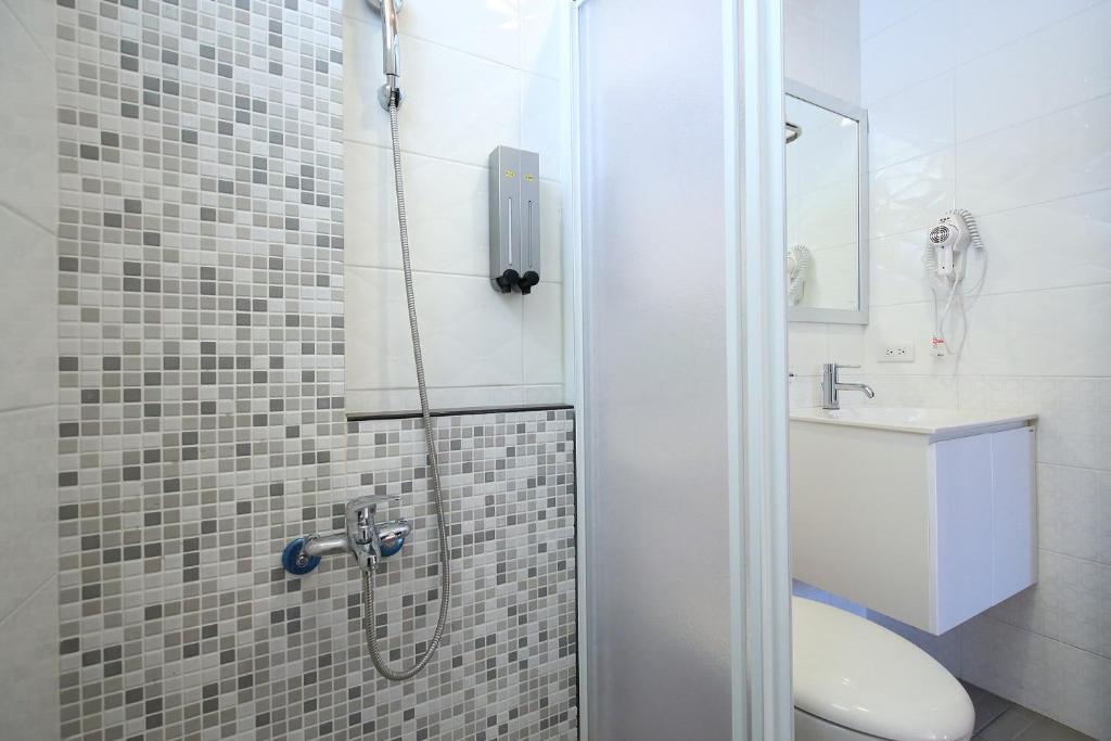 a bathroom with a shower with a toilet and a sink at Shanghai Time in Hualien City