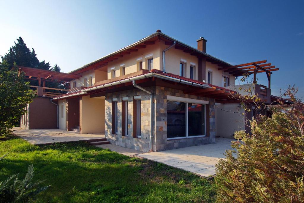 a house with a large patio in front of it at Butik Apartmanház in Fonyód