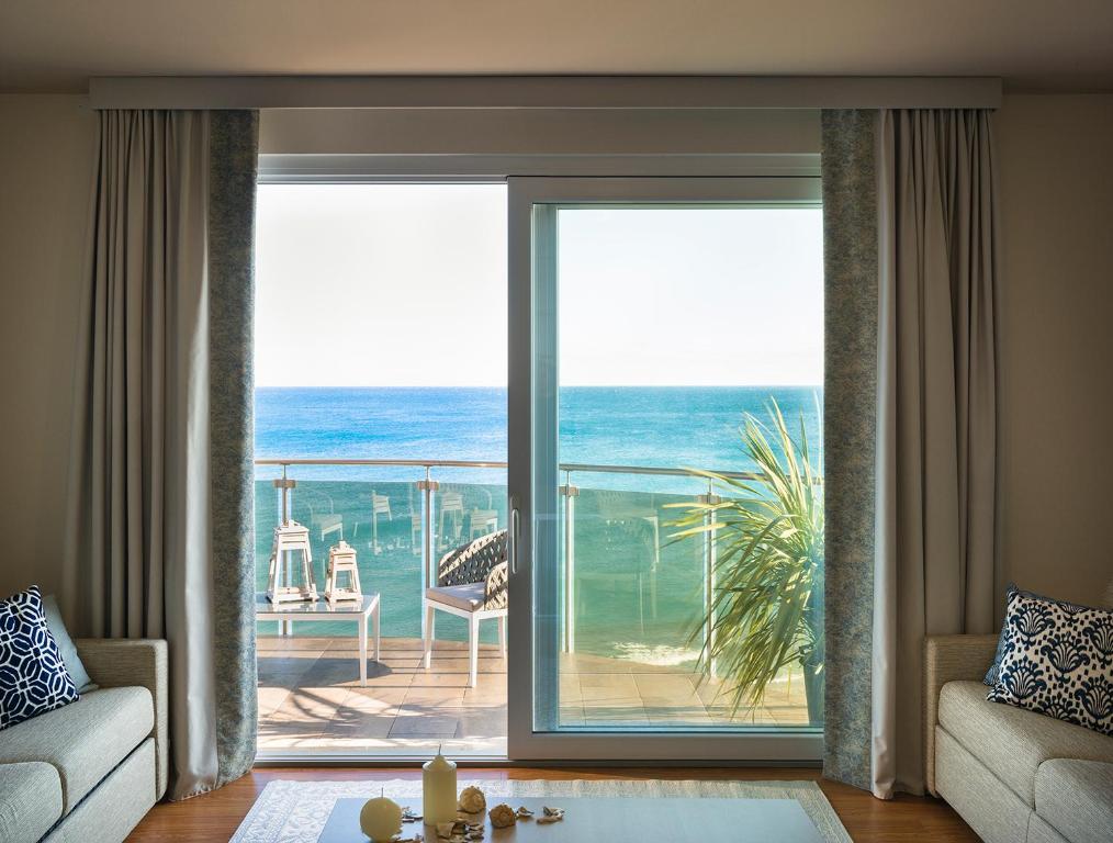 a living room with a view of the ocean at Grand Hotel Pietra Ligure in Pietra Ligure