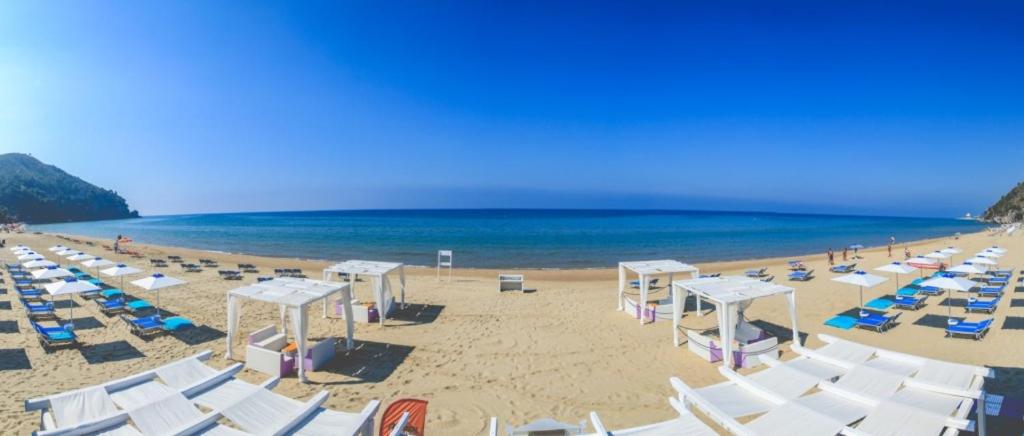 uma praia com cadeiras e guarda-sóis e o oceano em Il Volo em Sperlonga
