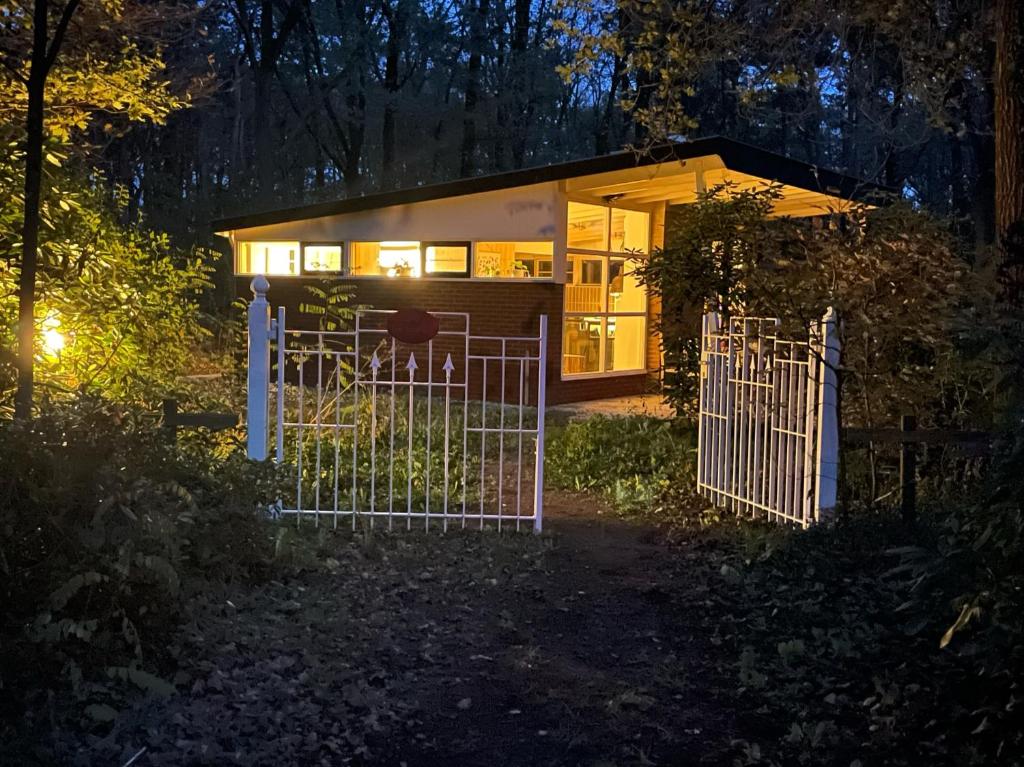una pequeña casa con una puerta por la noche en Ecolodge Bergzicht de Specht Luxe boshuis, en Barchem