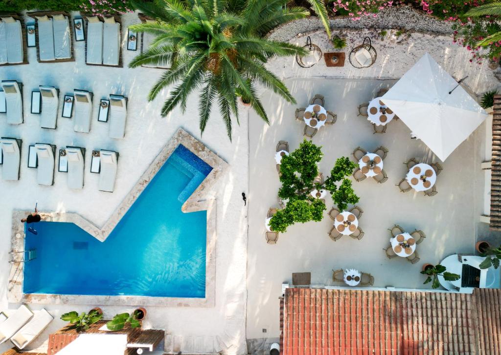 an overhead view of a swimming pool with chairs and umbrellas at Hotel Galfi - Boutique & Adults Only in San Antonio