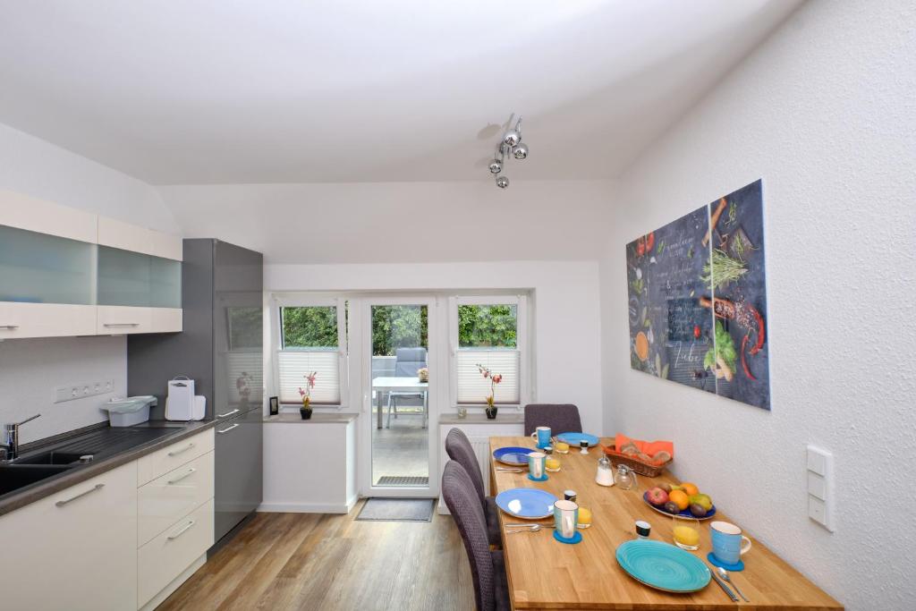 uma cozinha e sala de jantar com uma mesa de madeira num quarto em Ferienwohnung Schwarting em Wiefelstede