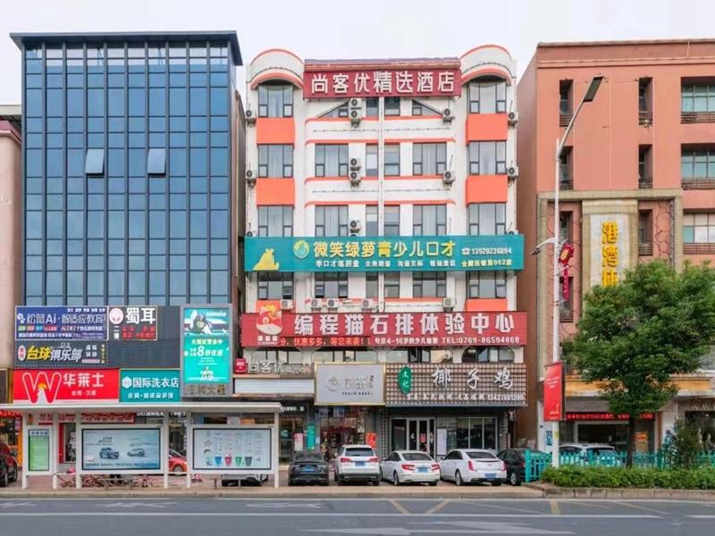 una calle de la ciudad con coches estacionados frente a los edificios en Thank Inn Plus Hotel Guangdong Dongguan Shipai Park, en Dongguan