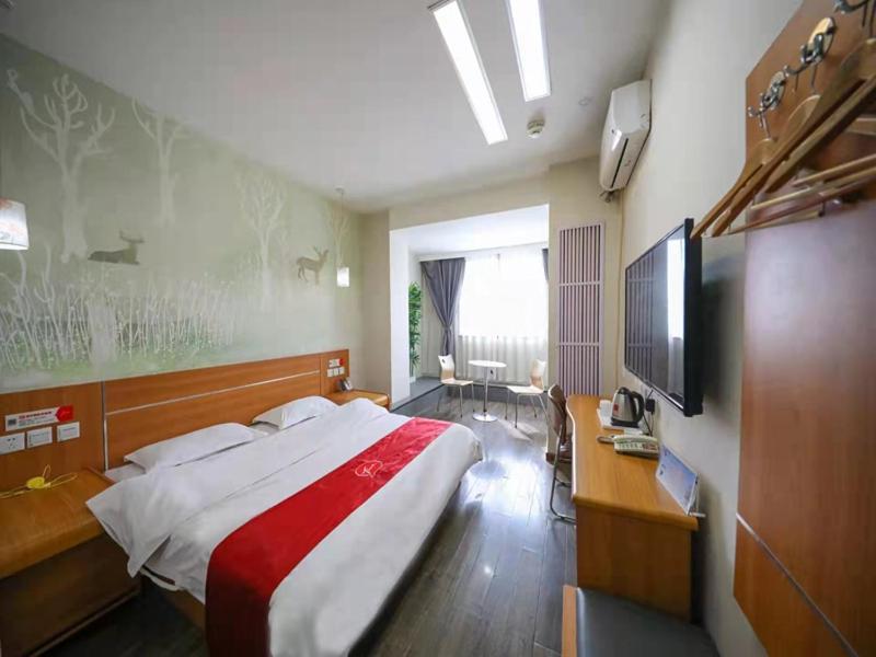 a bedroom with a large bed and a desk at Thank Inn Chain Hotel Gansu Tianshui Taian Bus Station in Tianshui