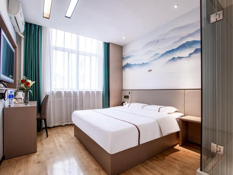 a bedroom with a large white bed and a desk at Thank Inn Plus Cangzhou Weiming Road Huabei Commercial Building in Cangzhou