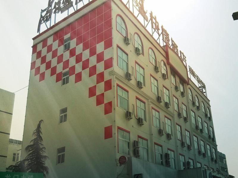 a tall building with red and white squares on it at Thank Inn Chain Hotel Henan Luoyang Longmen Avenue Guanlin Road in Luoyang