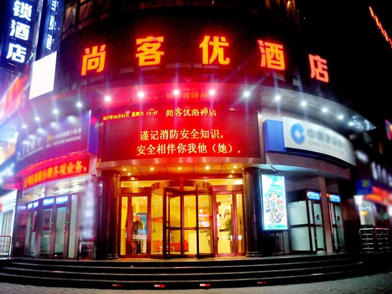 ein Gebäude mit Neonschildern davor in der Unterkunft Thank Inn Plus Hotel Henan Luoyan Yanshi Luosheng Building in Yanshi
