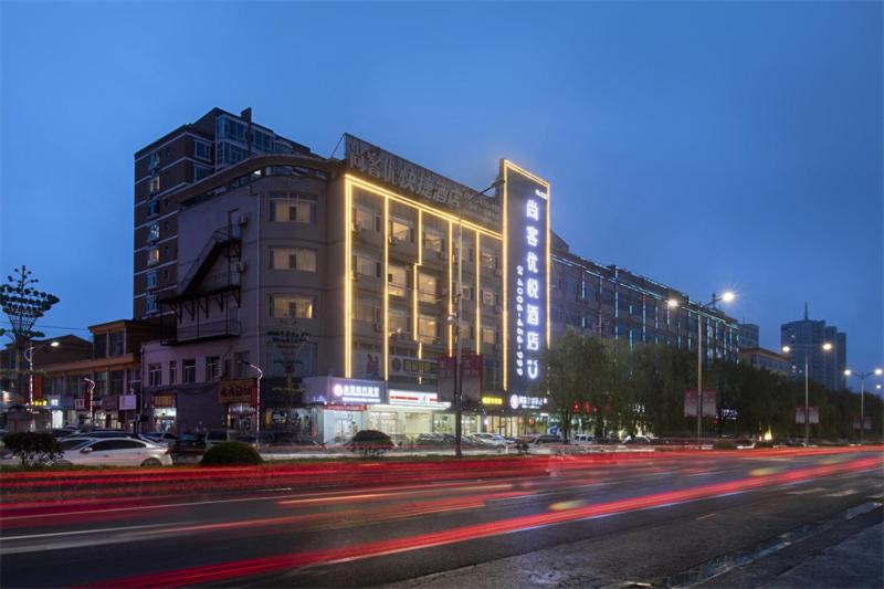 un edificio en una calle de la ciudad por la noche en Thank Inn Chain Hotel Shanxi Yangquan Yu County West Xiushui Street, en Yu