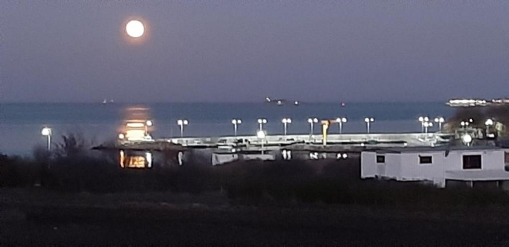 a full moon rising over the ocean at night at Capitan Niko Apartments in Burgas