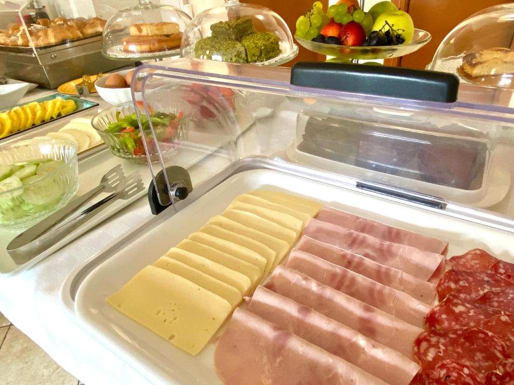 an open refrigerator with cheese and meats and other foods at Hotel Sylesia in Letojanni