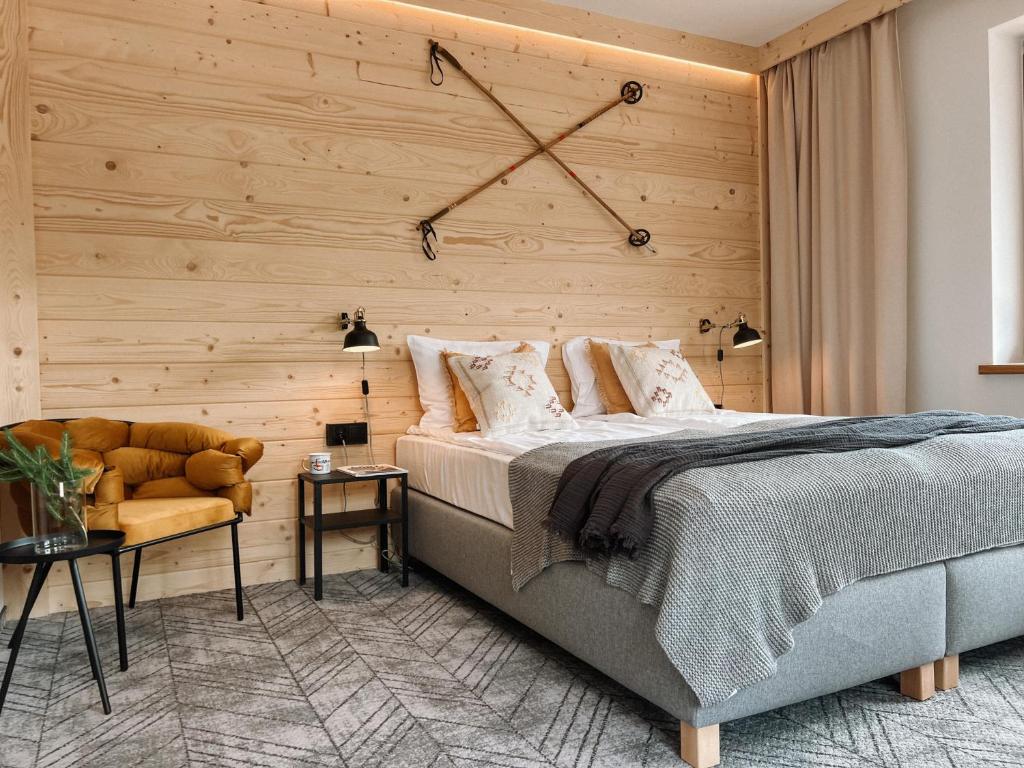 1 dormitorio con 1 cama y pared de madera en Dom Górski 878 mnpm en Zakopane