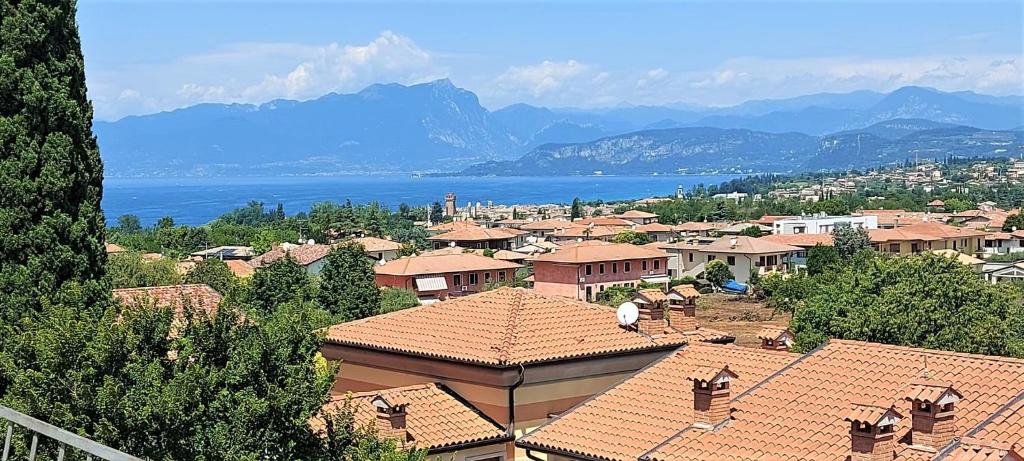 a view of a town with roofs and a lake at Al Glicine Apartments in Lazise
