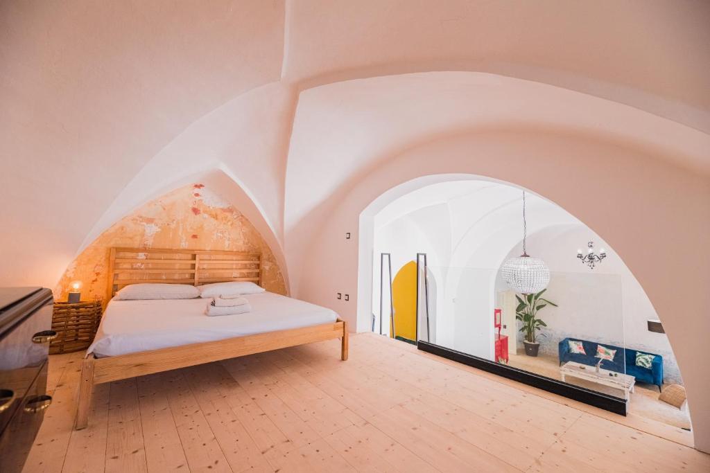 een slaapkamer met een bed in een kamer met een boog bij Casa delle Rondini in Presicce