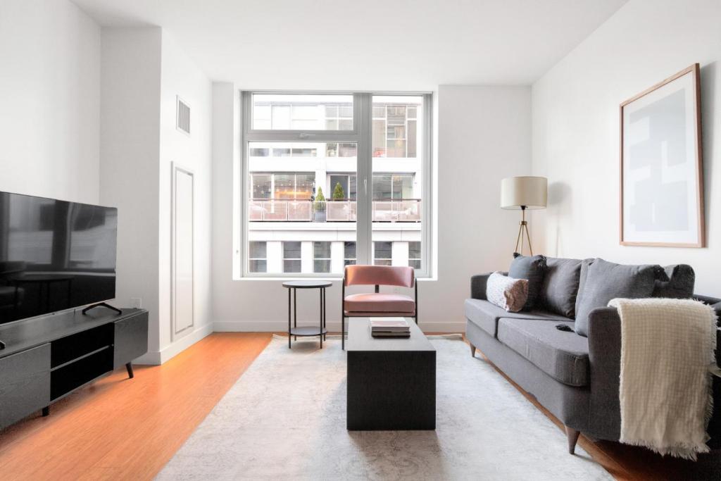 a living room with a couch and a tv at Downtown 1BR w Gym WD nr S Station BOS-618 in Boston