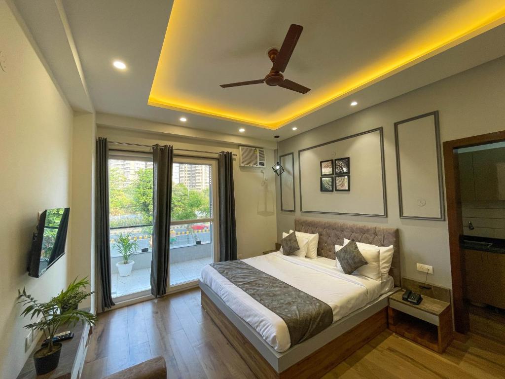a bedroom with a bed and a ceiling fan at The Empire Suites in Gurgaon