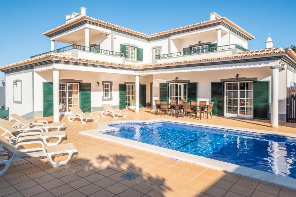 een villa met een zwembad en een huis bij Villa Isa - Heated Pool - Free wi-fi - Air Con in Guia