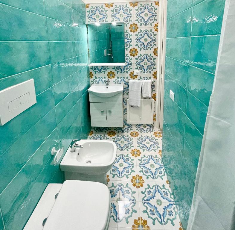 a blue bathroom with a toilet and a sink at Conte125 in Cinisi