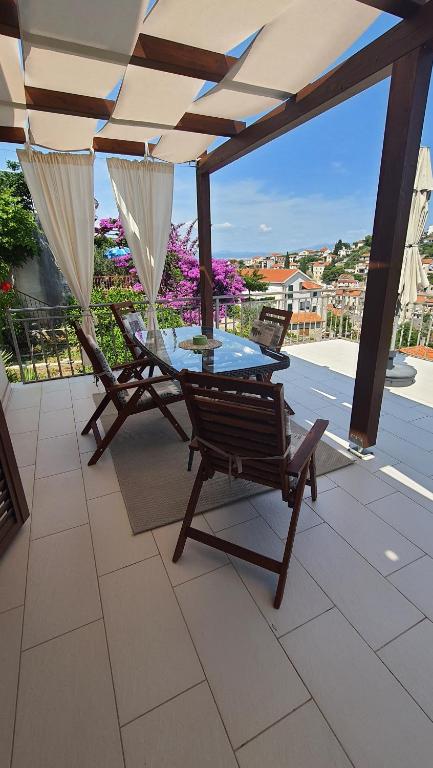 a table and chairs on a patio with an umbrella at Apartments with sea view in Stomorska