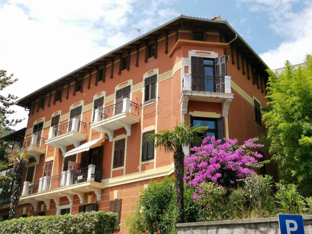an orange building with a balcony and pink flowers at Romeo&amp;Juliet in Opatija
