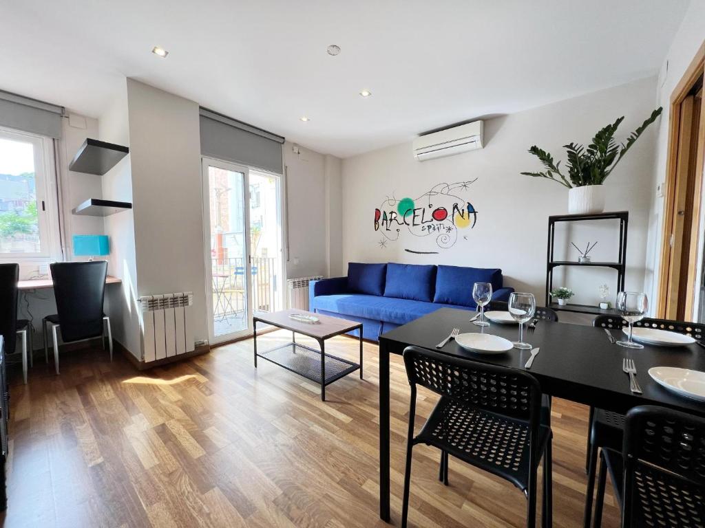 een woonkamer met een blauwe bank en een tafel bij Teatro Miro Apartment in Barcelona