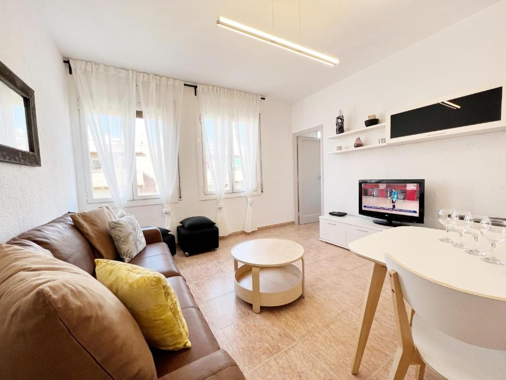 a living room with a couch and a tv at Villa Olimpica Beach in Barcelona