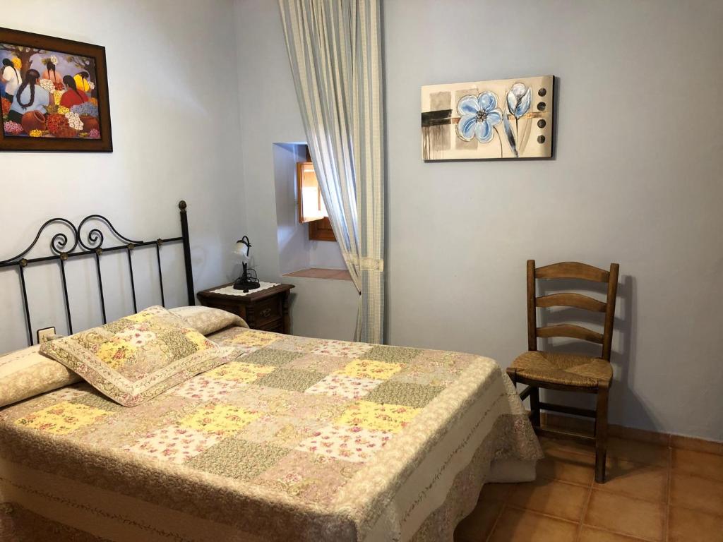 a bedroom with a bed and a chair and a painting at CASA JUANITO PEÑA in Parauta