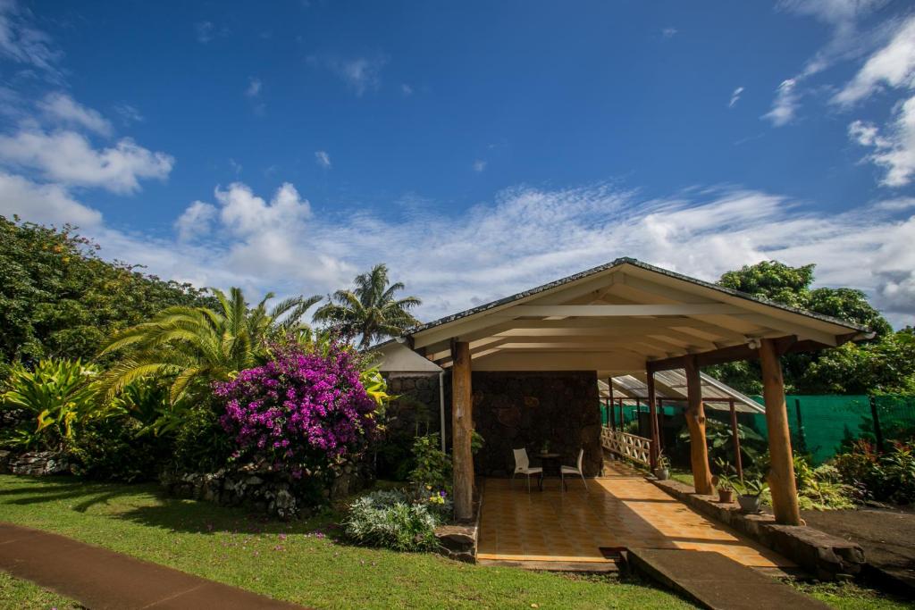 un gazebo in legno in un cortile fiorito di Hostal Uruhao a Hanga Roa