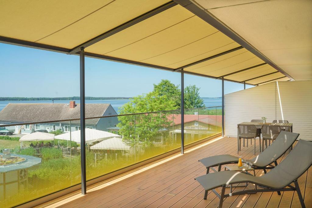 a large screened porch with a view of the water at Appartements "Zum Leuchtturm" Hafen Rankwitz Insel Usedom in Rankwitz