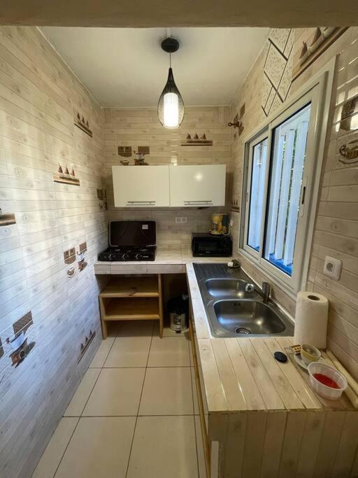 una pequeña cocina con fregadero y ventana en Maison T3 75m2 en Ouangani
