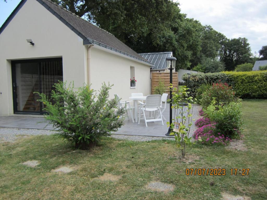 une maison blanche avec une table et des chaises dans une cour dans l'établissement Villa Atlantique, à Assérac