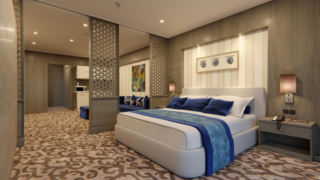 a bedroom with a large bed with blue pillows at AlHamra Hotel Kuwait in Kuwait
