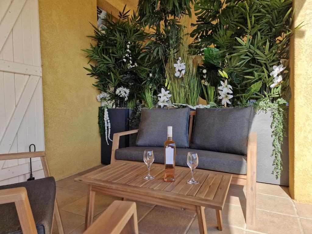 - une table avec une bouteille de vin et des verres sur un canapé dans l'établissement Appartement Vue Mer, à Fréjus