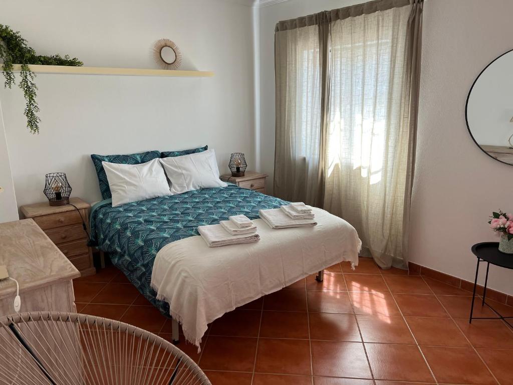 a bedroom with a bed with towels on it at Casa de praia em Almograve in Almograve
