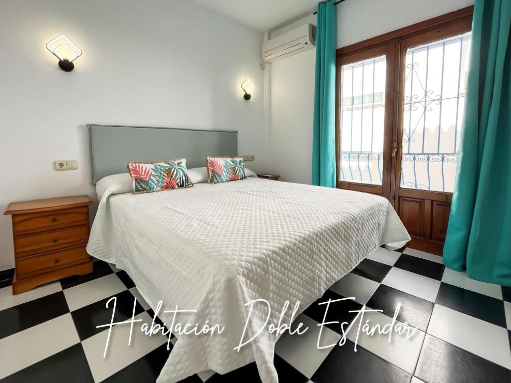 a bedroom with a bed and a checkered floor at Micaela Charming Hostal in Torremolinos